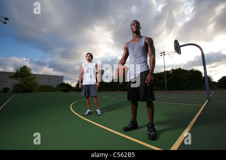 males after after playing basketball on outdoor court, dramatic sky Stock Photo