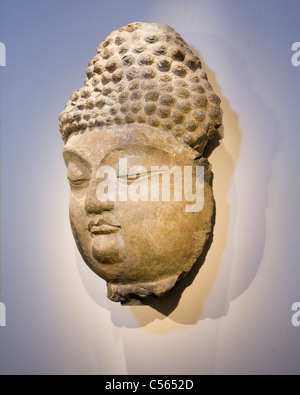 Stone sculpture of Buddha hanging on wall Stock Photo