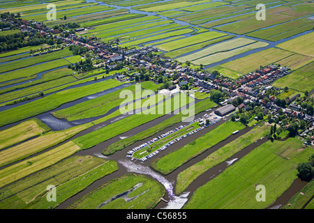 Netherlands, Wormer, Polder with village and farmland and mooring place with small boats. Aerial. Stock Photo