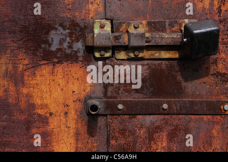 Door lock hangs on a rusty gate Stock Photo