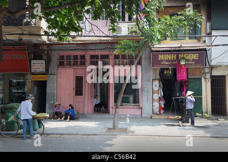 Hanoi Vietnam street scene, roadside shops with sellers, traders Stock Photo