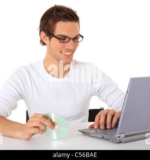Smiling young guy using notebook computer. All on white background. Stock Photo