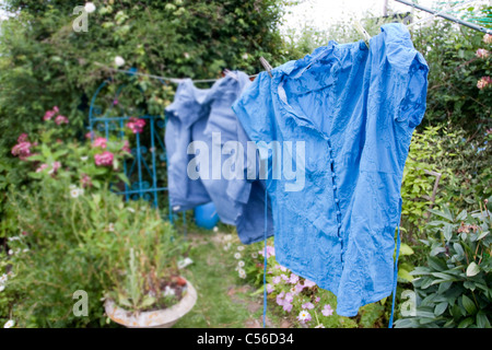 washing out drying on the line in a beautifual garden, blue shirts from the laundry Stock Photo