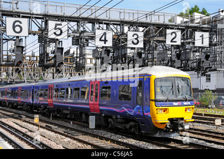 Side & front view First Great Western train below Royal Oak signal gantry with very large numbers on approach to Paddington station London England UK Stock Photo