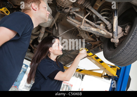 Two mechanics looking at a car discussing a problem Stock Photo