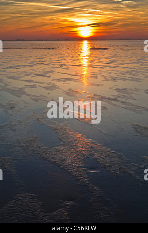 The Netherlands, Marken, Frozen lake called IJsselmeer. Sunset. Stock Photo