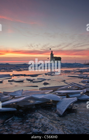 The Netherlands, Marken, Frozen lake called IJsselmeer. Lighthouse called Het Paard. Sunrise. Piled up ice. Stock Photo