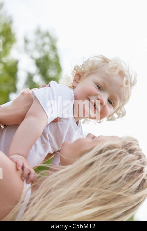 Portrait of baby boy playing with mother in park Stock Photo