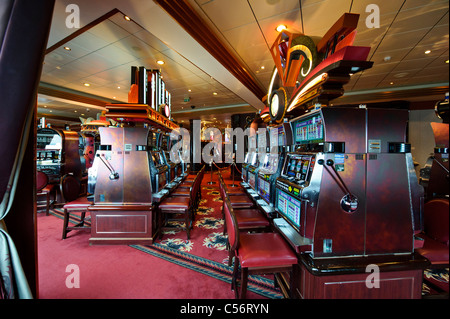 Slot machines for passenger usage in the Empire Casino on Deck 2, Queen Mary 2 Ocean Liner. Stock Photo