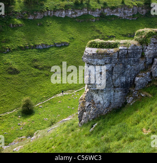 Solitary walker in the deep limestone valley of Lathkill Dale in the Derbyshire Peak District Stock Photo