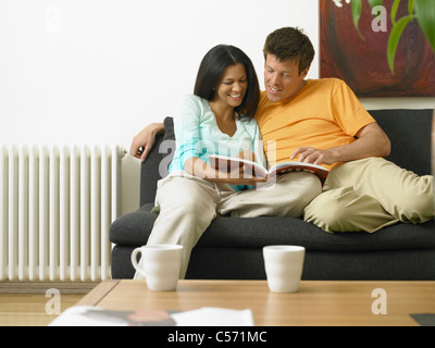Couple reading on couch together Stock Photo