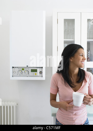 Woman having cup of coffee in kitchen Stock Photo