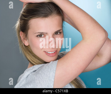 Smiling woman with hands in hair Stock Photo