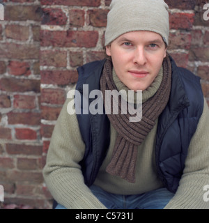 Man leaning against brick wall Stock Photo