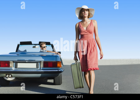 Woman leaving man in convertible Stock Photo