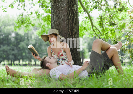 Couple relaxing under tree together Stock Photo
