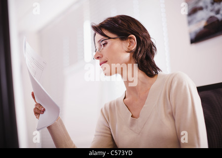 Businesswoman reading document in office Stock Photo