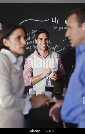 Worker behind counter at cafe Stock Photo