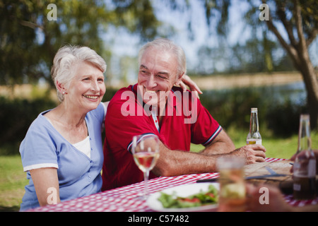 Older couple sitting at picnic table Stock Photo