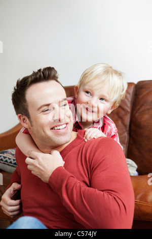 Father and son hugging on sofa Stock Photo