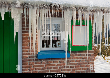 The Netherlands, Staphorst, Winter, Icicles on farm roof. Stock Photo