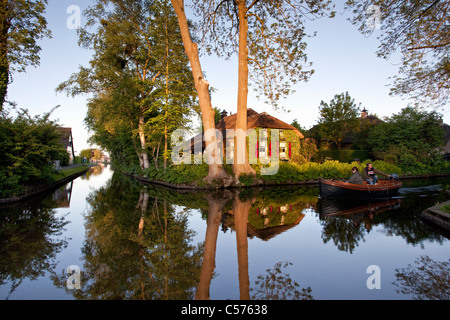 The Netherlands, Giethoorn, Village with almost only waterways. Tourists enjoying boat ride. Stock Photo