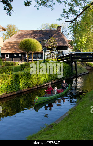 The Netherlands, Giethoorn, Village with almost only waterways. Tourists enjoying kayak ride. Stock Photo