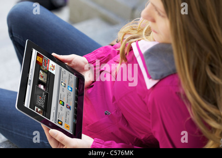 Close up view of a young woman browsing the online Apple application store using an Ipad 2 Stock Photo