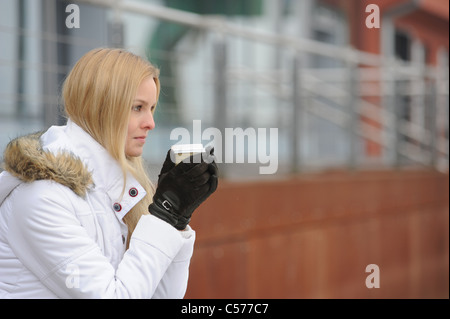 Woman in winter clothes drinking coffee Stock Photo