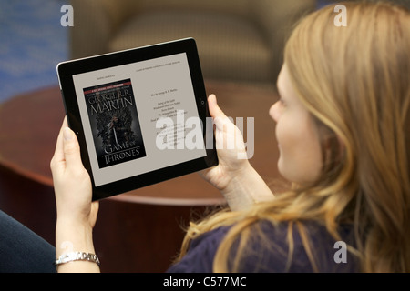 Close up view of a Caucasian young woman reading 'A Game of Thrones' book from Kindle Ipad 2 application Stock Photo