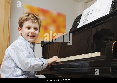 Boy playing the piano in living room Stock Photo