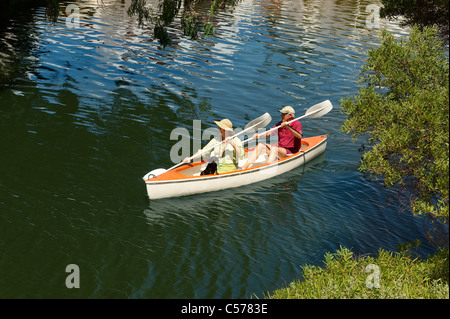 Older couple rowing canoe on lake Stock Photo