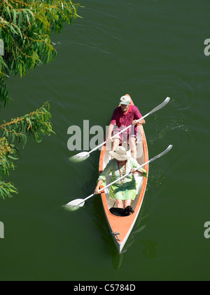 Older couple rowing canoe on lake Stock Photo