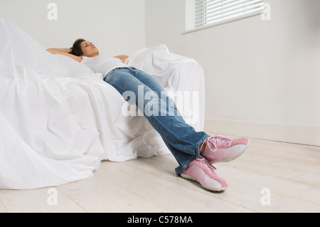 Woman resting on couch in new home Stock Photo