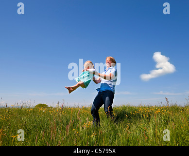 Father and daughter playing in field Stock Photo