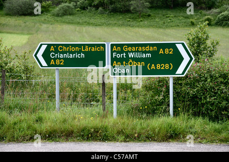 Road signs in English and Gaelic at Glencoe village in the Scottish Highlands. Stock Photo