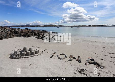Martyrs bay on Iona with a sand castle and stones spelling out the word Iona Stock Photo
