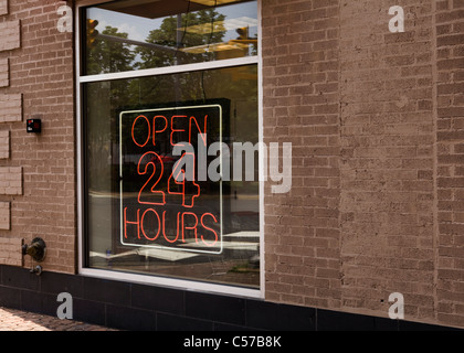 Red Open 24 Hours neon sign in window Stock Photo