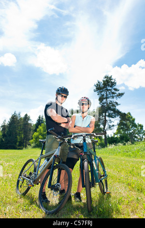 Sport mountain biking happy couple relax in meadows sunny countryside Stock Photo