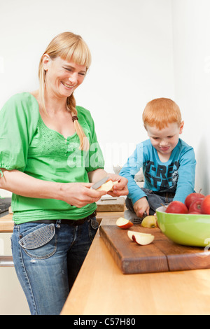Mother and son slicing apples together Stock Photo