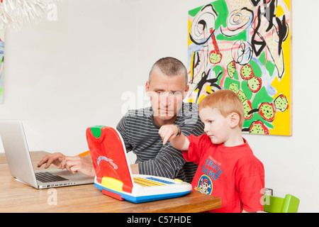 Father and son working on laptops Stock Photo