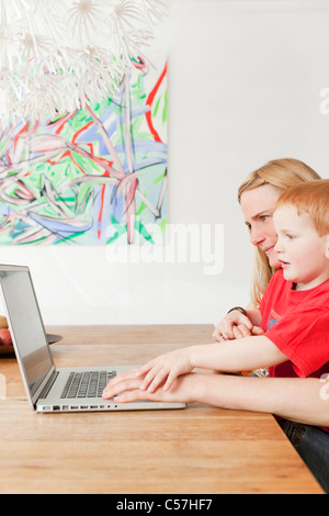 Mother and son using laptop together Stock Photo