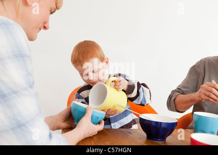 Boy pouring milk for mother Stock Photo