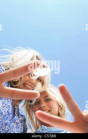 Sisters making peace sign together Stock Photo