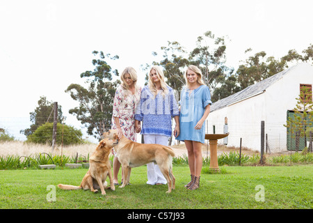 Mother and daughters with dogs in garden Stock Photo