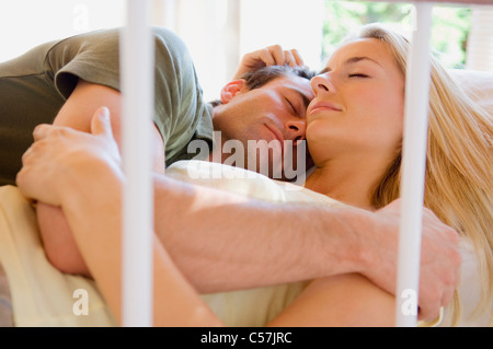 Sleeping couple hugging in bed Stock Photo