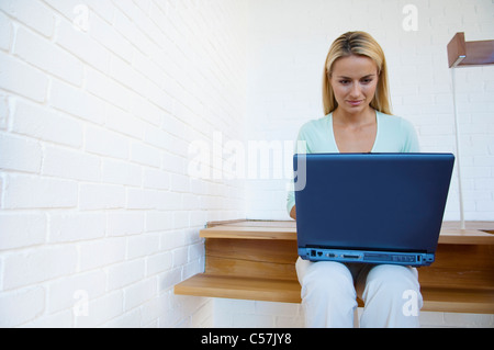 Woman using laptop on stairs Stock Photo