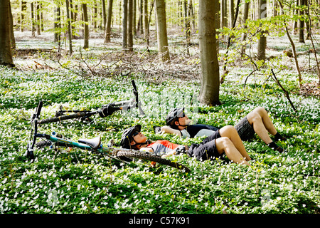 Mountain bikers relaxing in forest Stock Photo