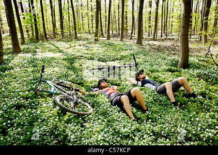 Mountain bikers relaxing in forest Stock Photo