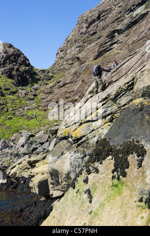 Walkers crossing The Bad Step at the foot of Sgurr na Stri on Loch Scavaig, Isle of Skye, Scotland, UK. Stock Photo